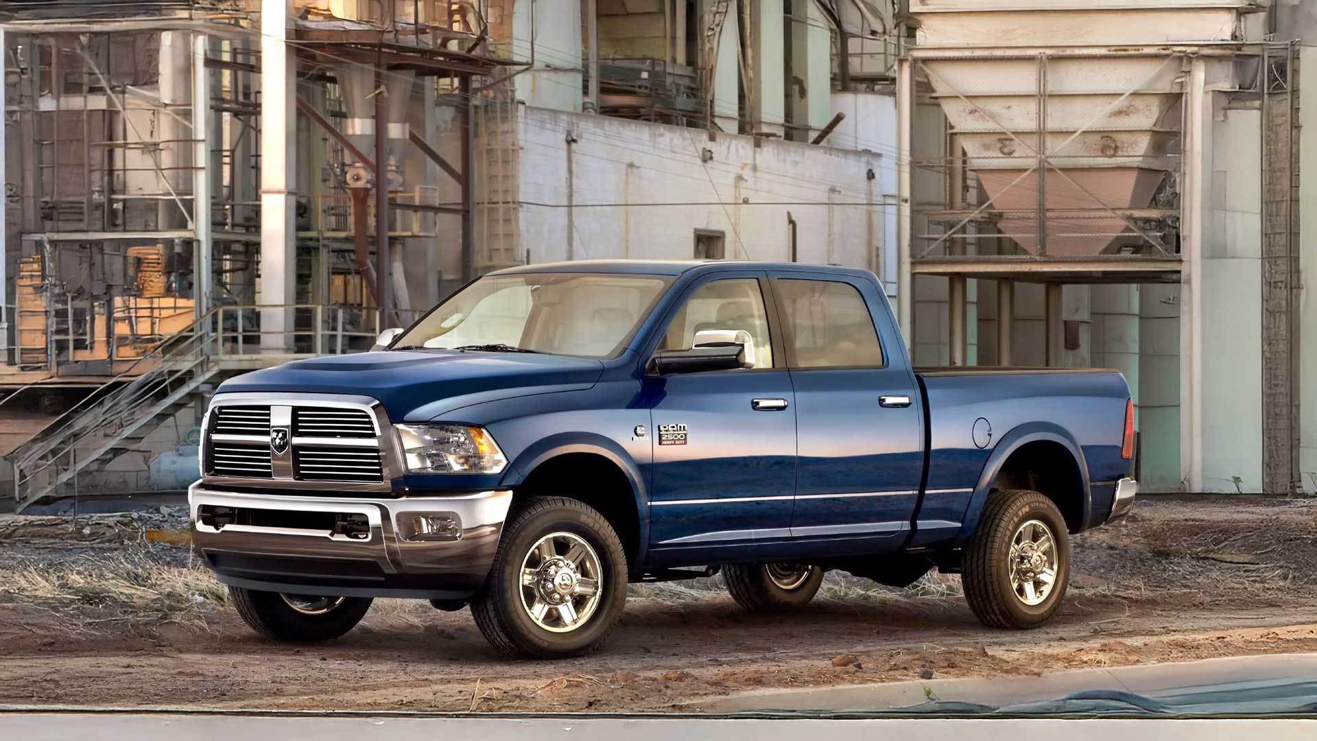 blue dodge ram 2500 crew cab with chrome wheels and factory tires in industrial setting