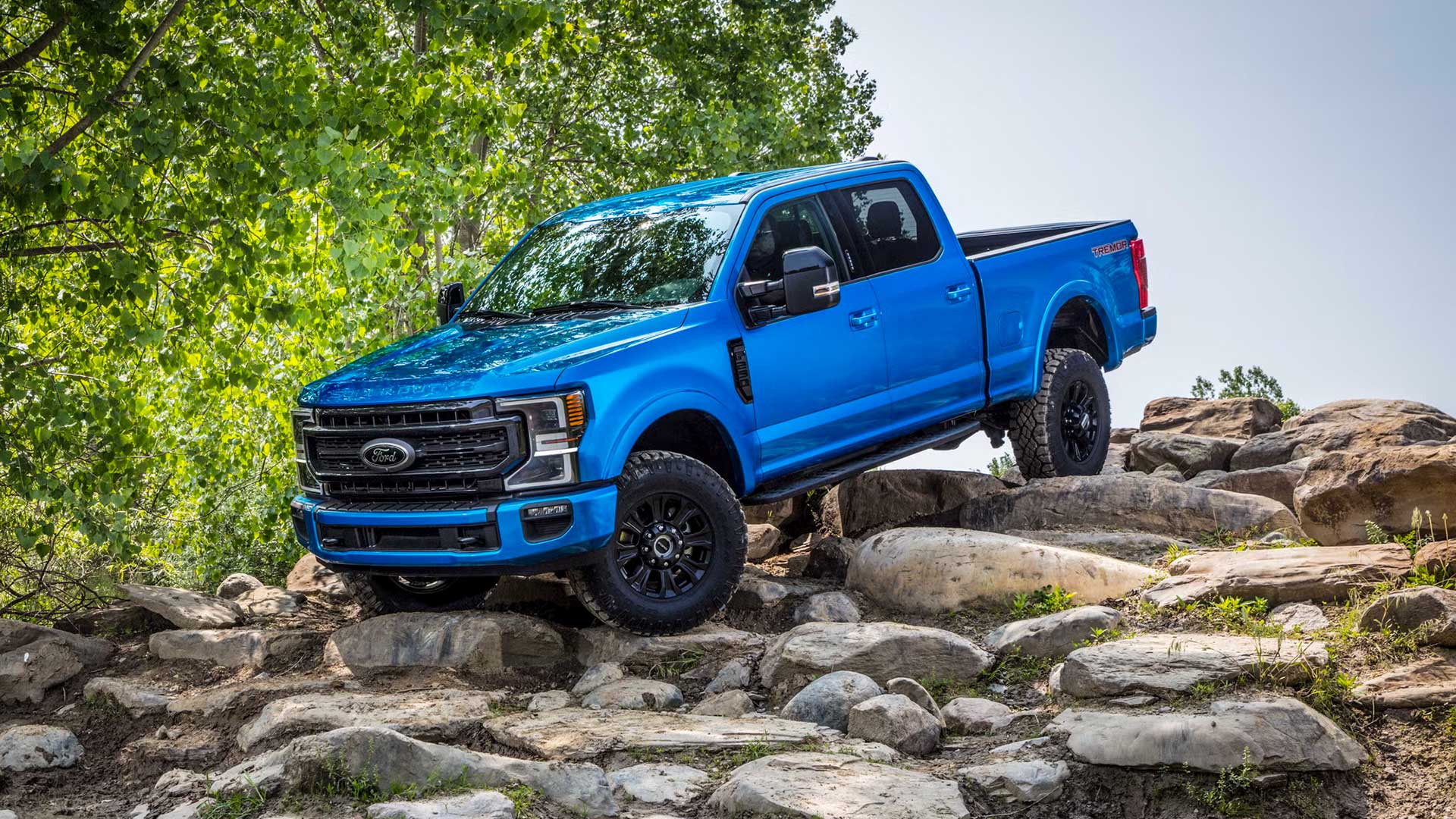 blue ford super duty climbing over rocky terrain