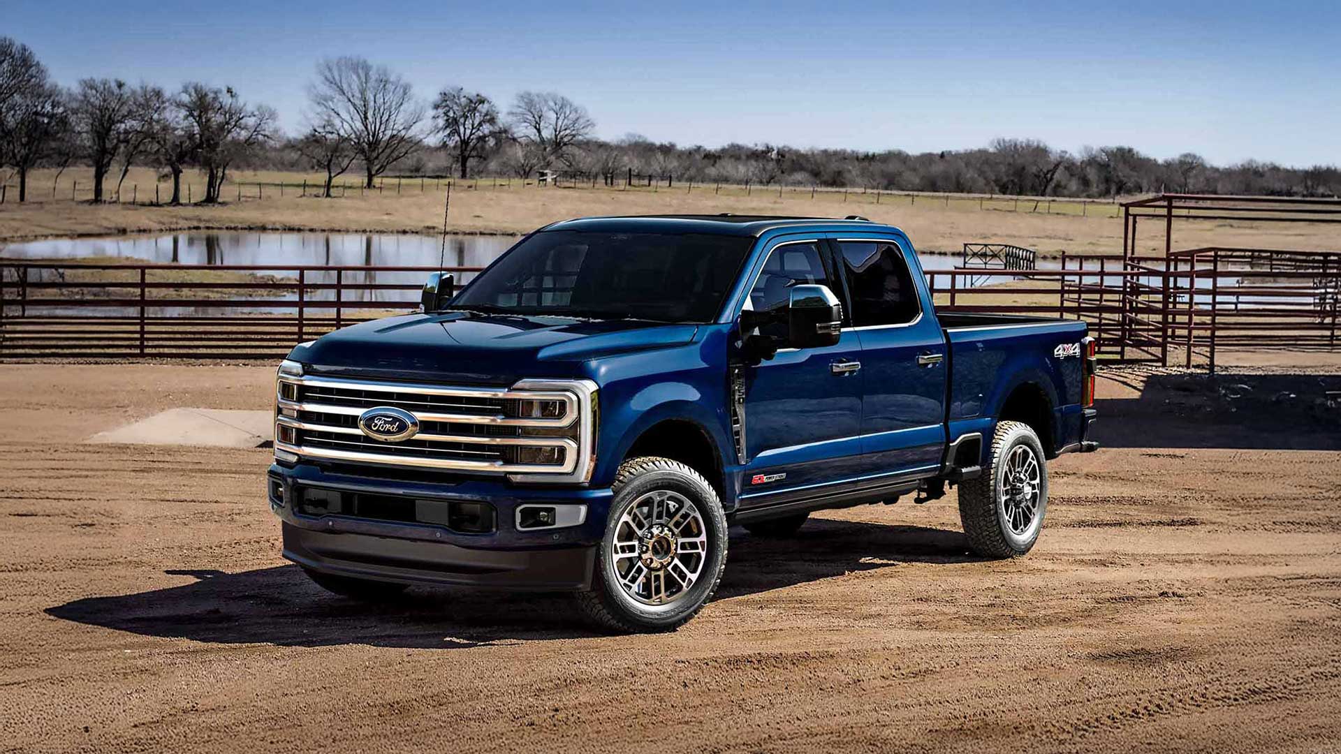 blue ford super duty pickup truck parked at ranch with pond