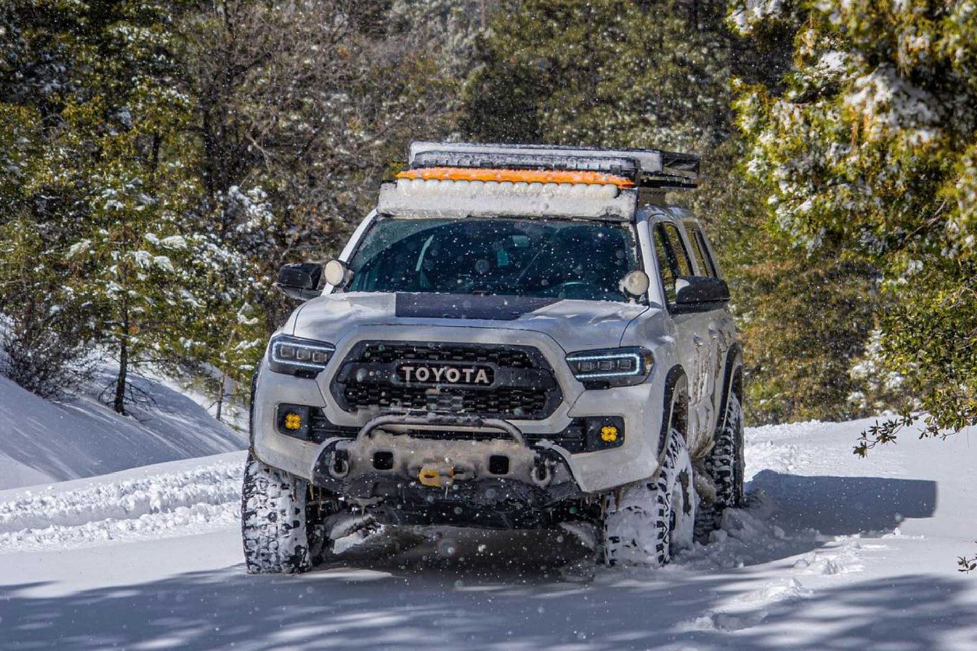 A Toyota Tacoma with RBP tires driving in snowy off-road conditions